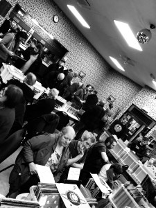 Stalls at a record fair with people milling around and crate-digging