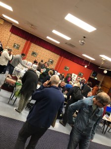 Stalls at a record fair with people milling around and crate-digging