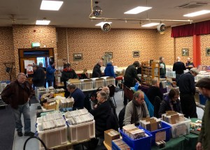 Stalls at a record fair with people milling around and crate-digging